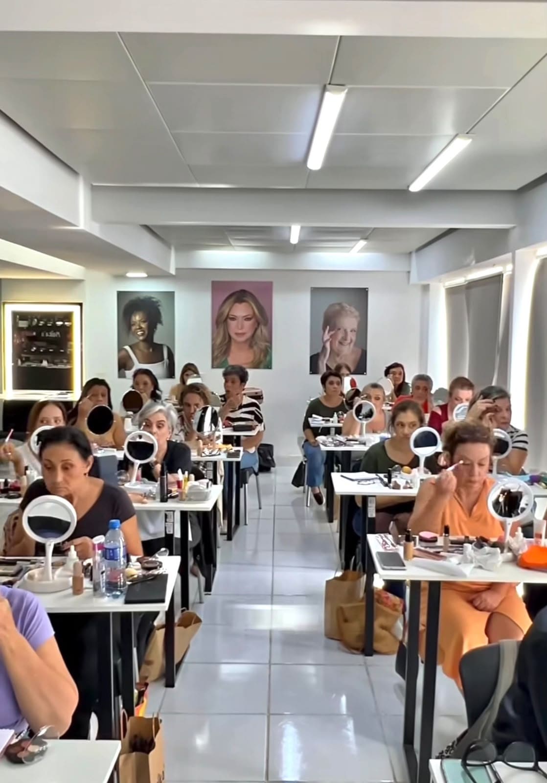Gi Cimino ensinando uma turma de automaquiagem